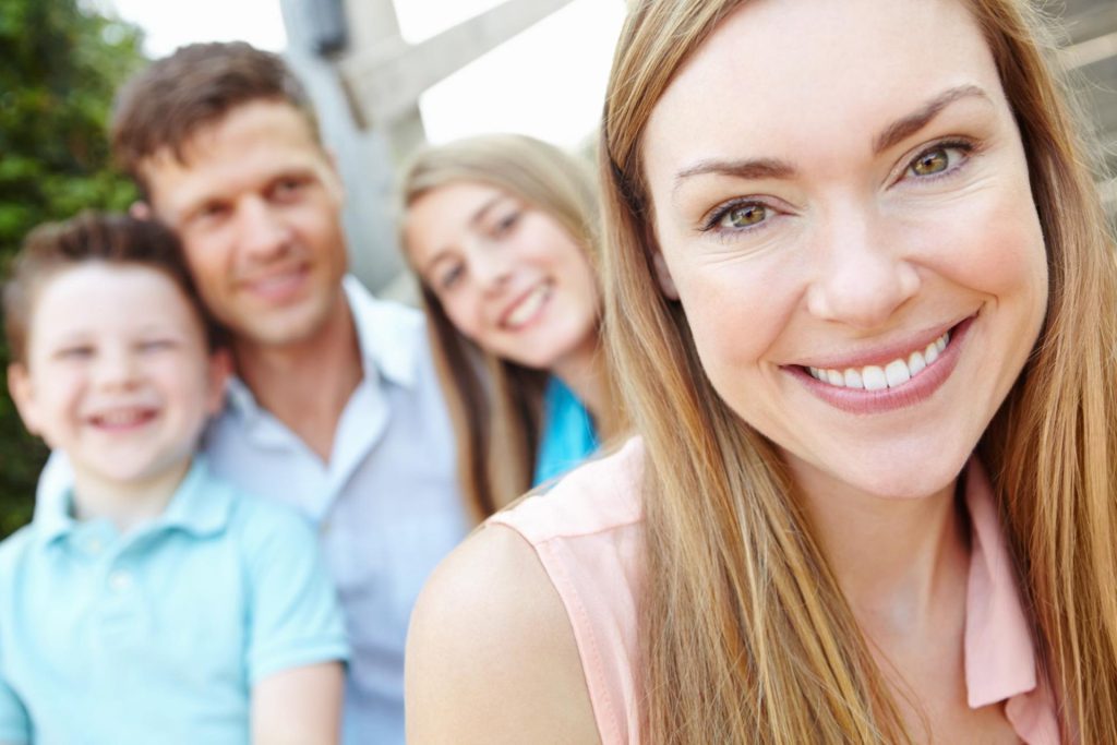 Familie mit strahlendem Lächeln im Portrait