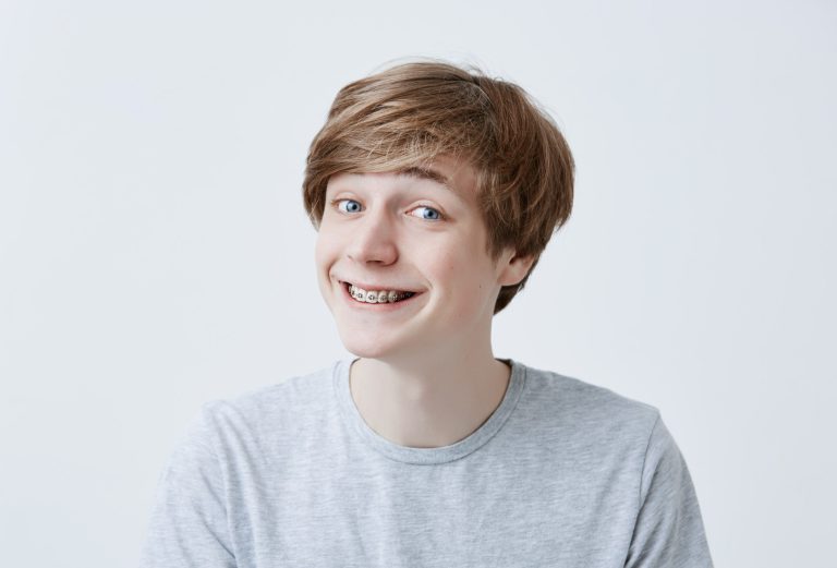 Jugendlicher mit Zahnspange lächelt