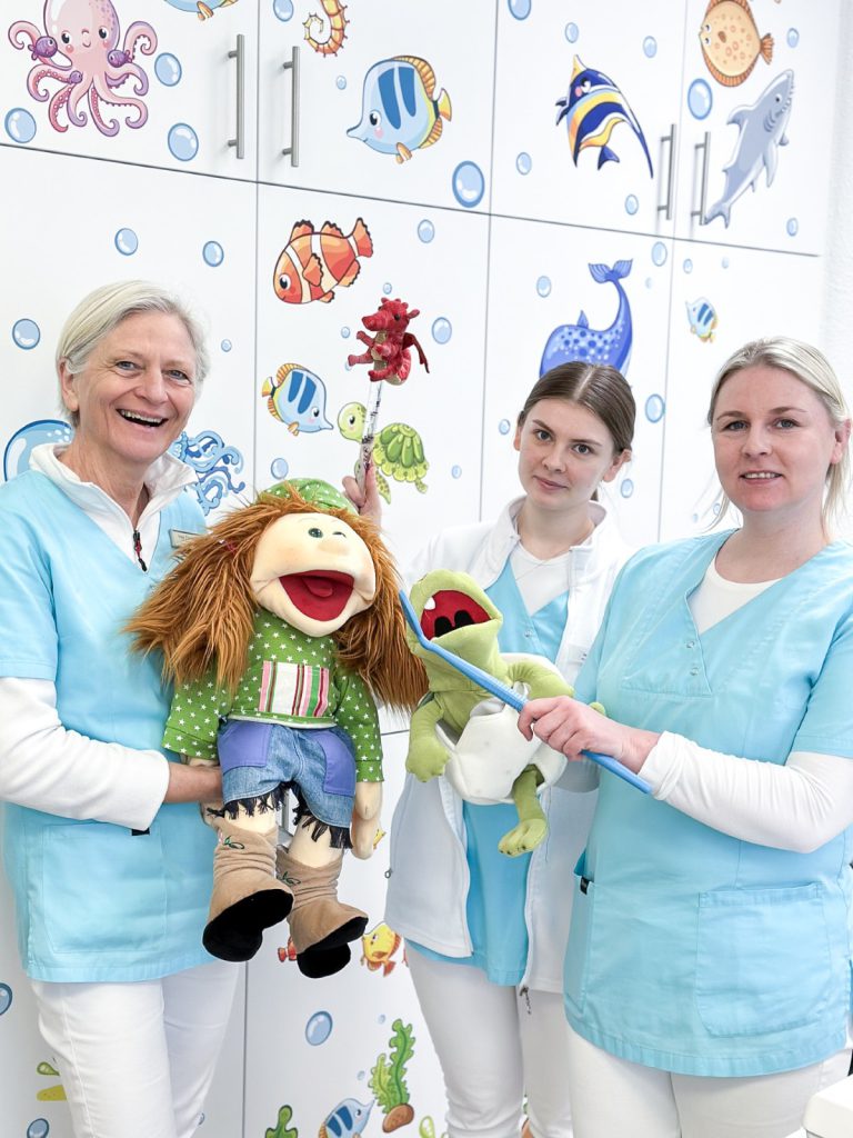 Praxisteam mit Handpuppen in der kinderfreundlichen Zahnarztpraxis