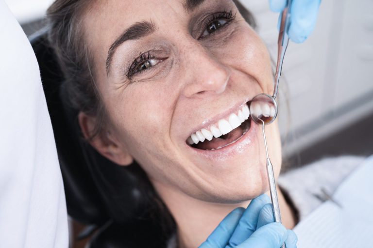 Patientin lacht während der Zahnbehandlung