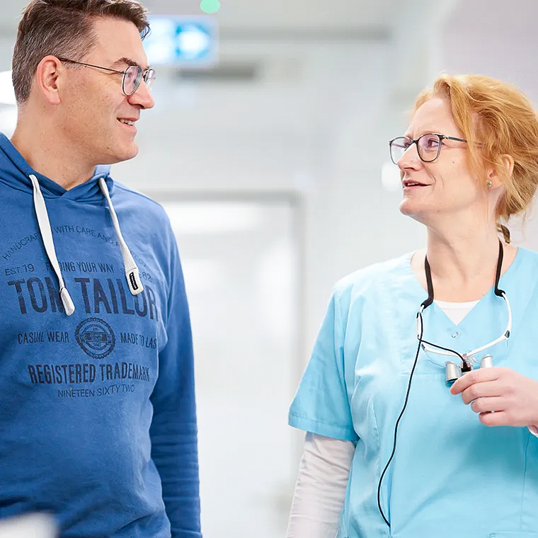 Zahnarzt erklärt Behandlung im Gespräch mit Patient