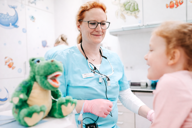 Zahnärztin behandelt Kind in kinderfreundlicher Atmosphäre