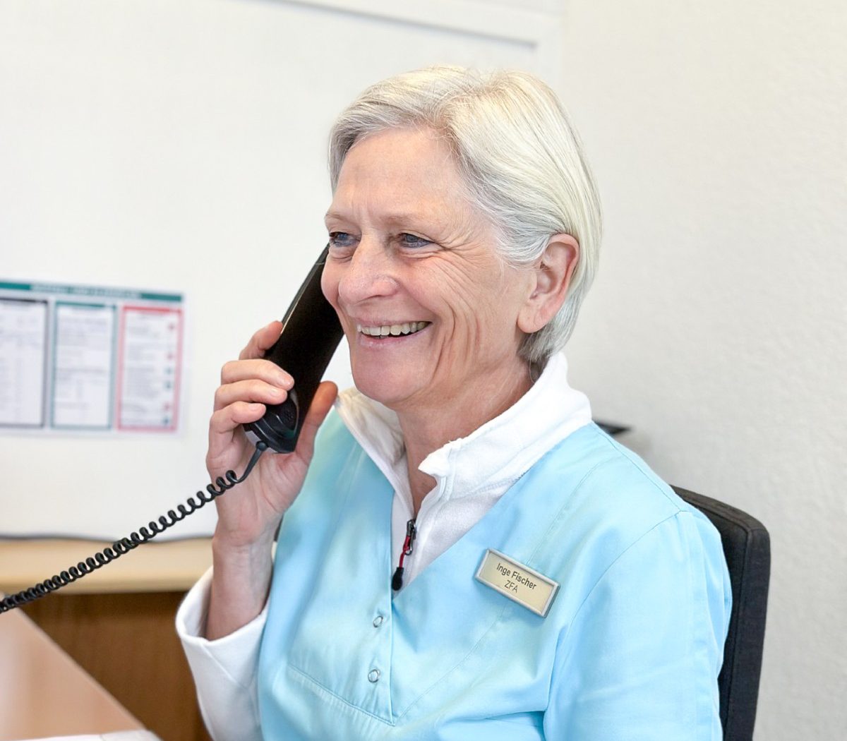 Mitarbeiterin der Zahnarztpraxis am Empfang beim Telefonieren