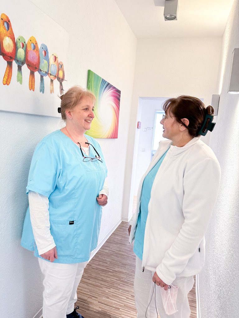 Mitarbeiterinnen der Zahnarztpraxis im Gespräch im Flur