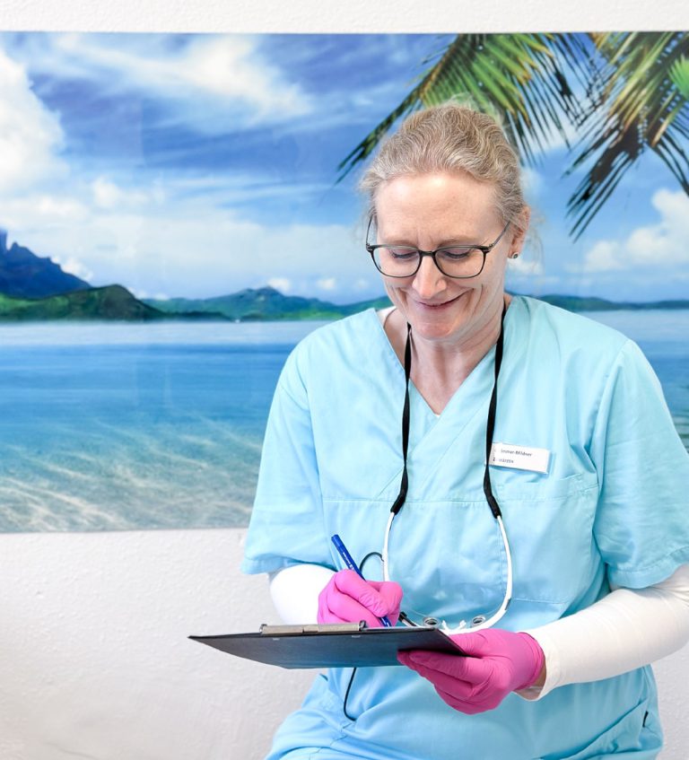 Zahnärztin dokumentiert Behandlung auf einem Tablet in der Praxis